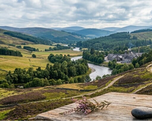 Speyside header: het landschap van de speyside met een distilleerderij op de achtergrond tegen het glooiende landschap